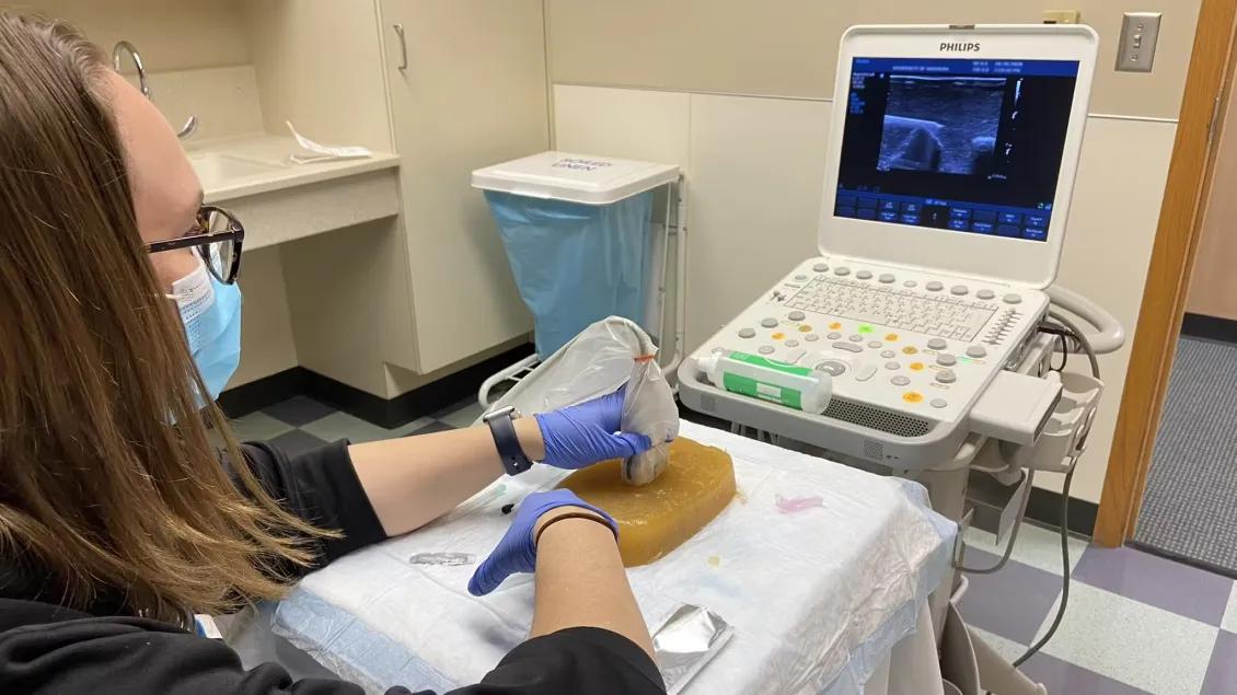 Resident using ultrasound equipment