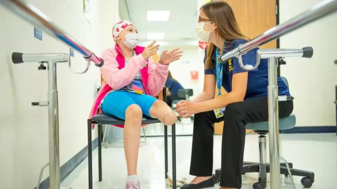 Health care provider talking to a pediatric cancer patient