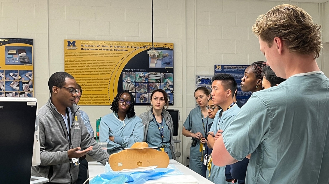 Group of trainees and instructor talking in the clinical simulation center