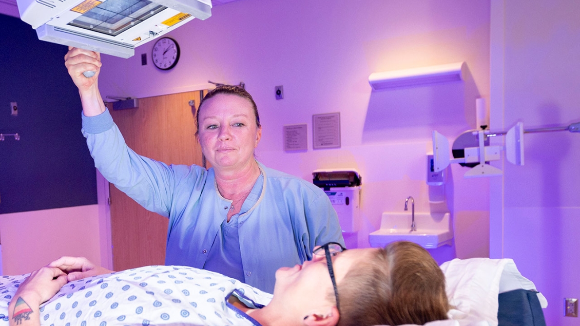 Female radiology provider assists patient with scan