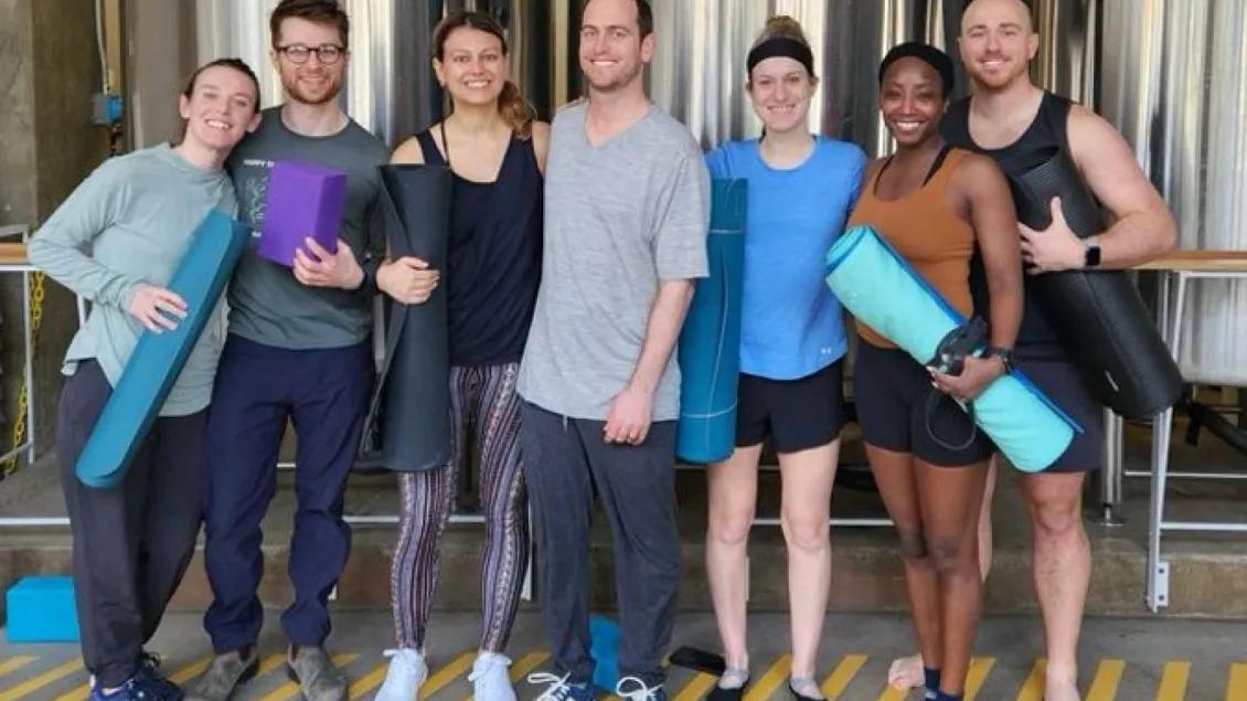 Psychiatry residents posing together holding rolled up yoga mats.