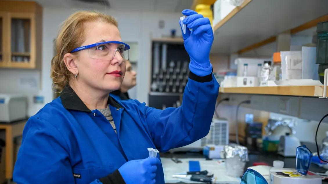 Lab member holding a test tube in the lab