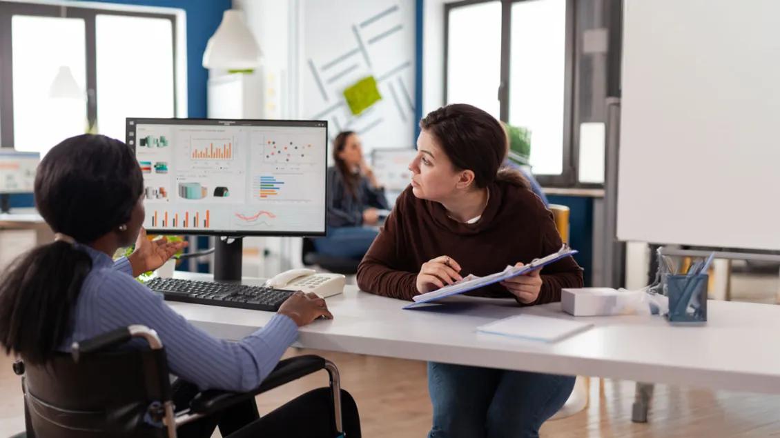 Two researchers review a dashboard of data at a table