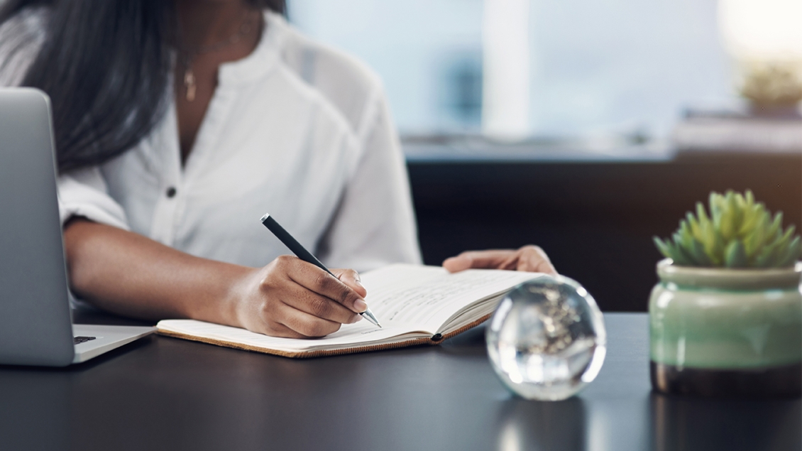 close-up of researcher writing in a notebook