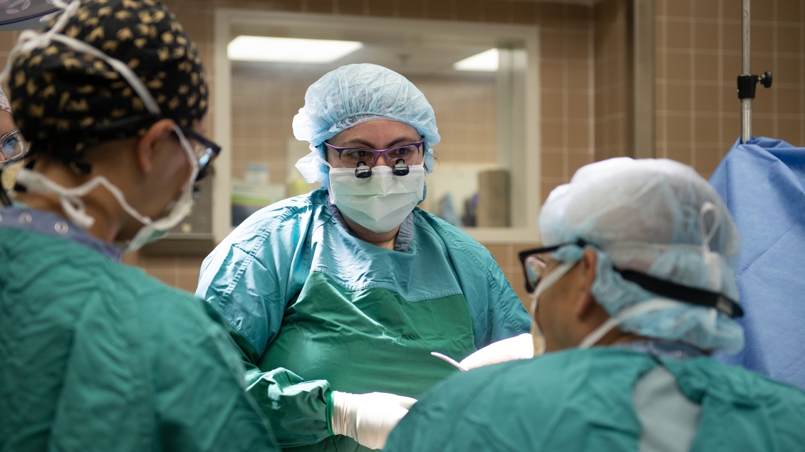 Three surgeons in an operating room doing hand surgery