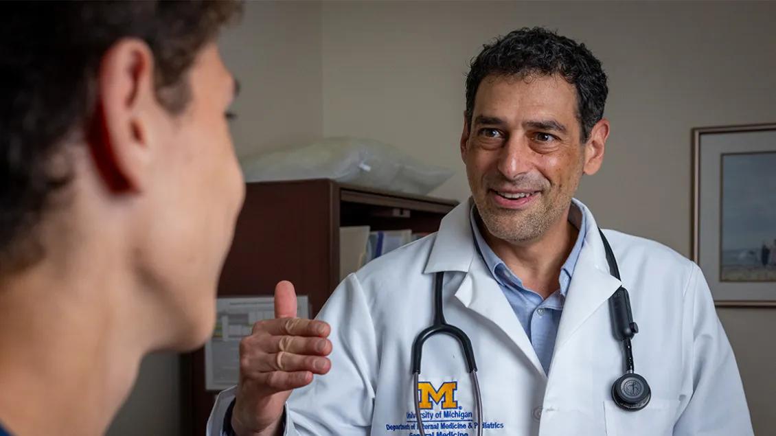 Dr. Kahn looking at boy patient smiling and explaining