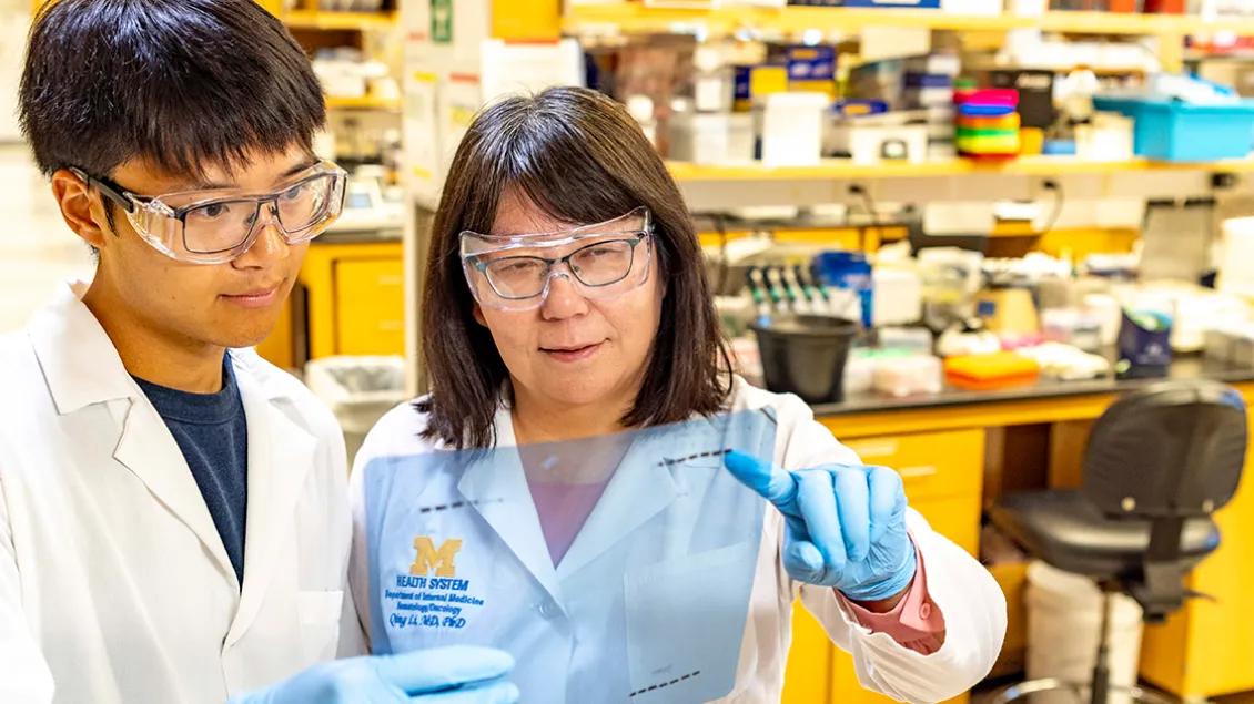 Dr. Li (left) with lab member looking at slide