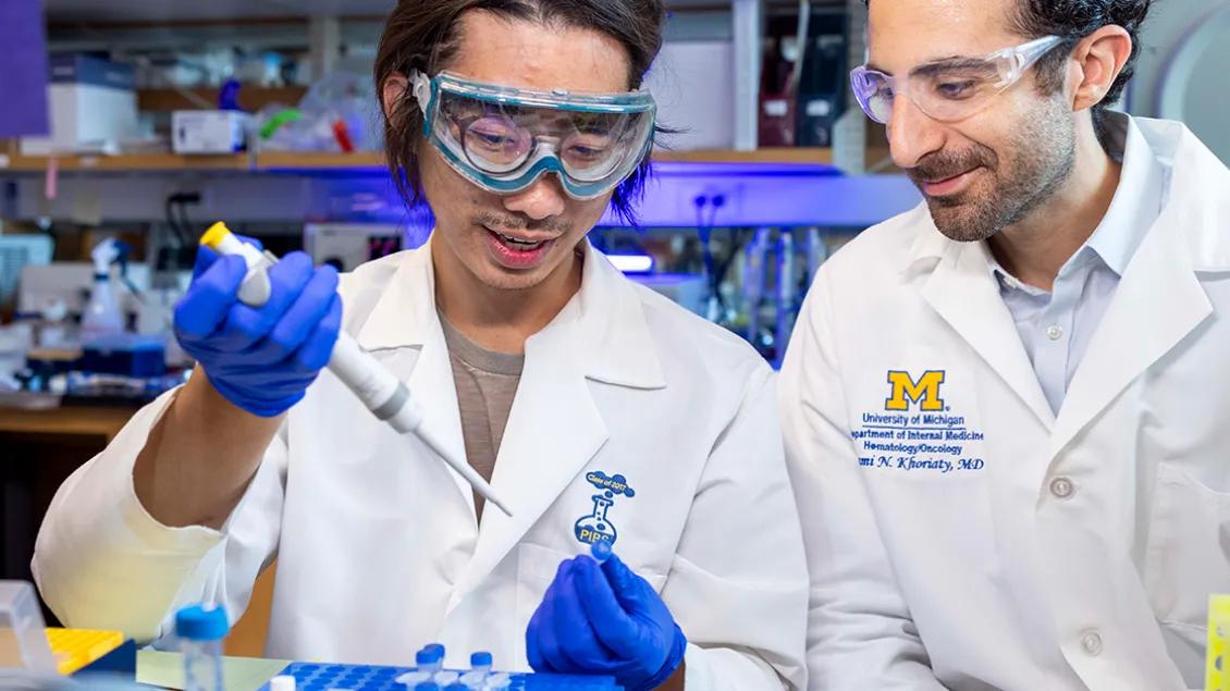 Dr. Khoriaty (left) with lab member pippetting