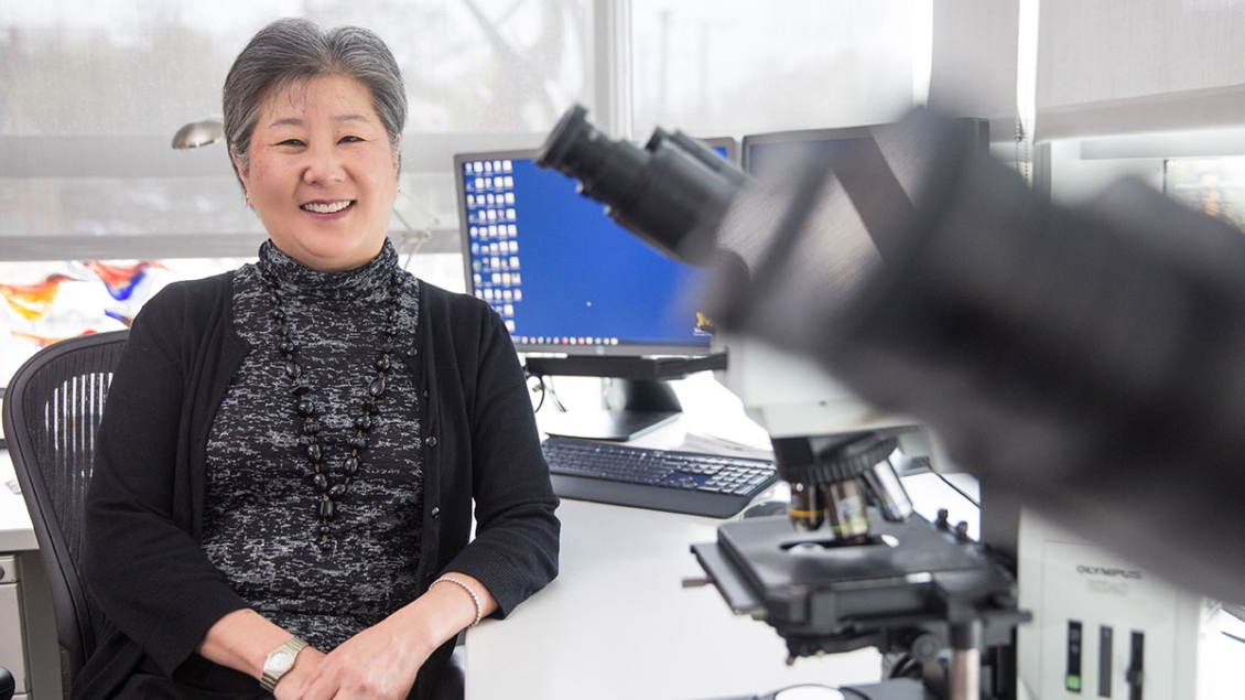 Dr. Kathleen Cho sits at her desk 