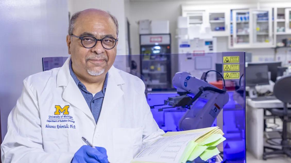 Alnawaz Rehemtulla on his lab, holding some papers.