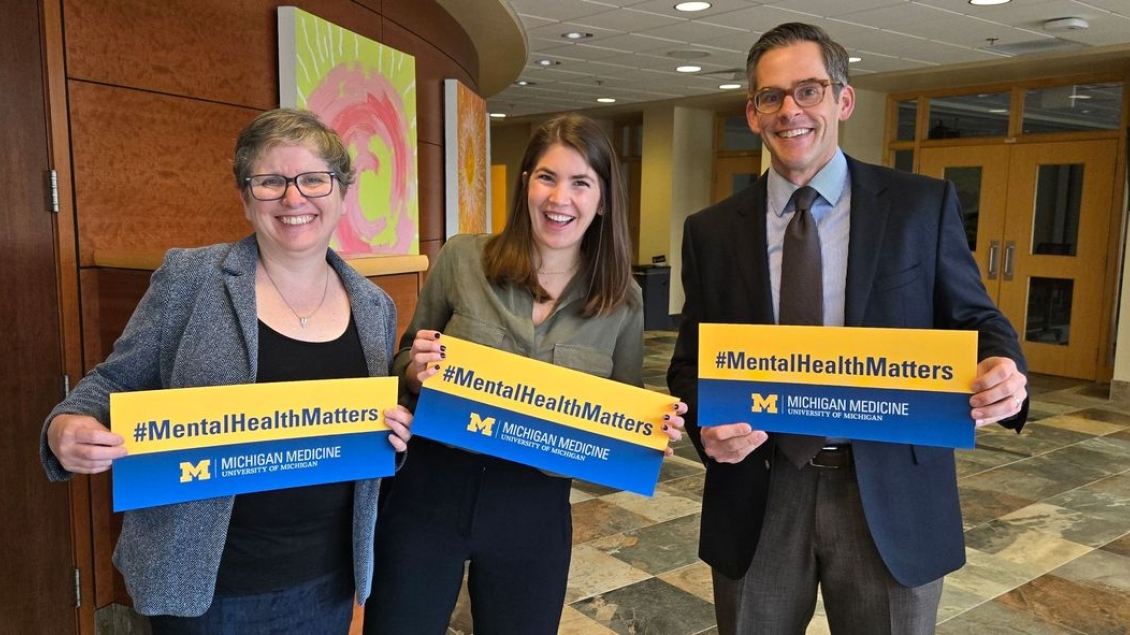 Three people holding up "Mental Health Matters" signs