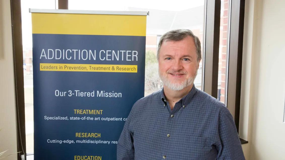 Person standing in front of an Addiction Center sign