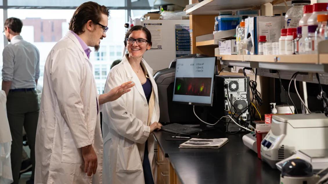 Two lab members discuss results looking at screen