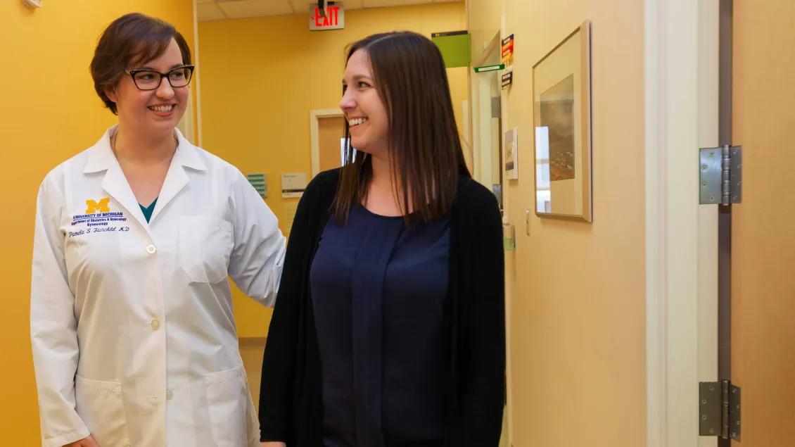 Doctor talking to someone in a clinic hallway