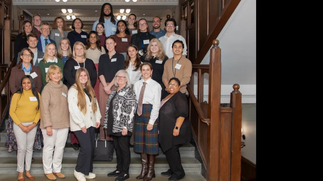 A team of more than twenty people standing on a staircase