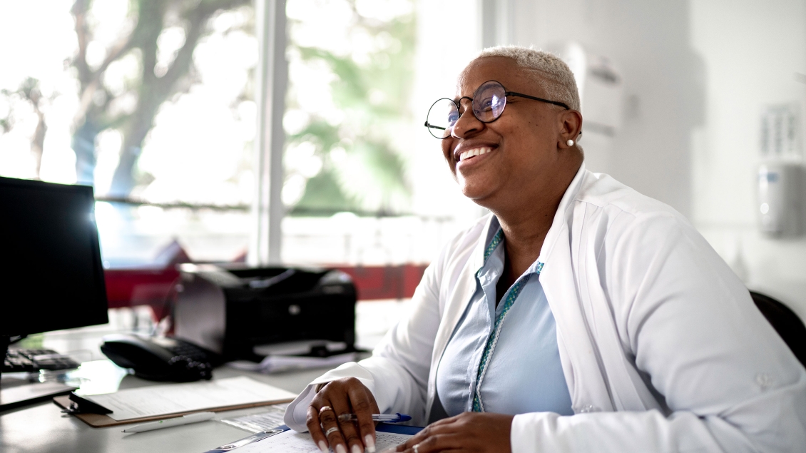 Doctor smiling and sitting at desk