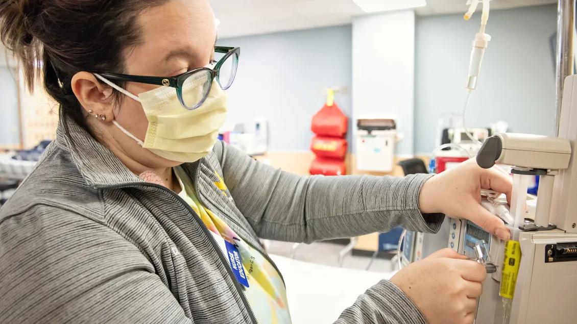 Nurse with mask on setting up an IV