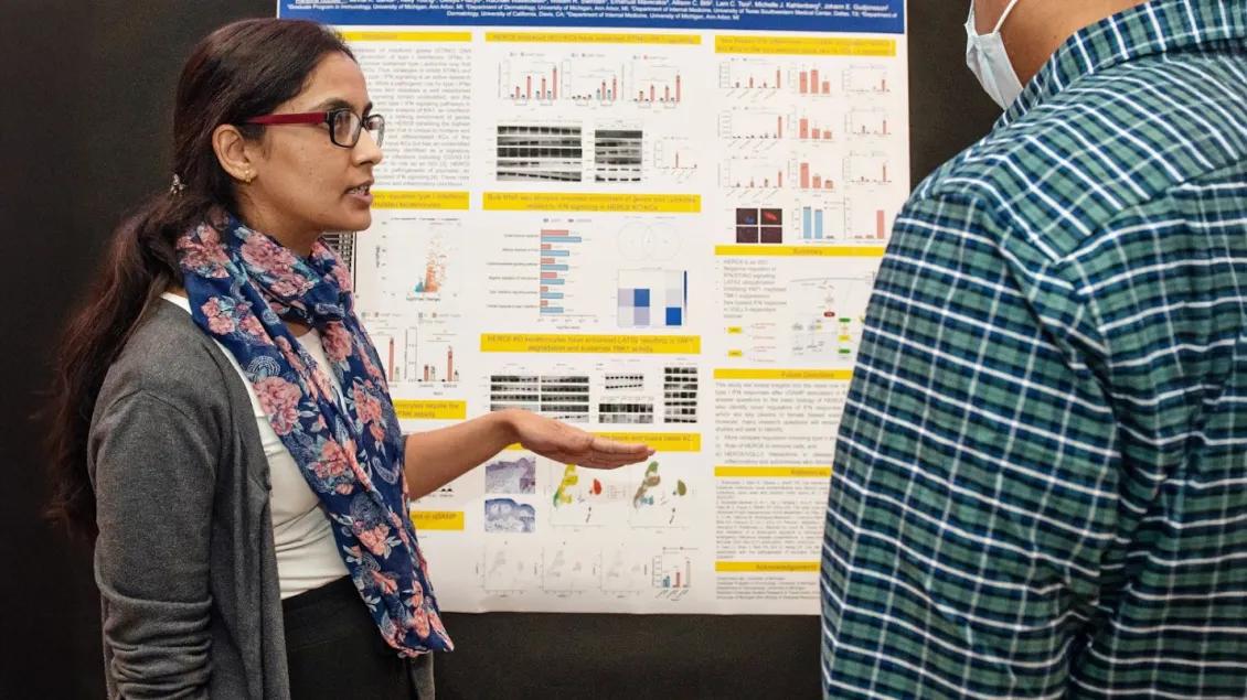 woman looking at research poster at symposium