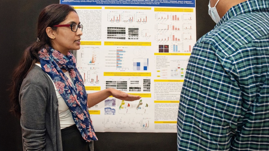 woman looking at research poster at symposium