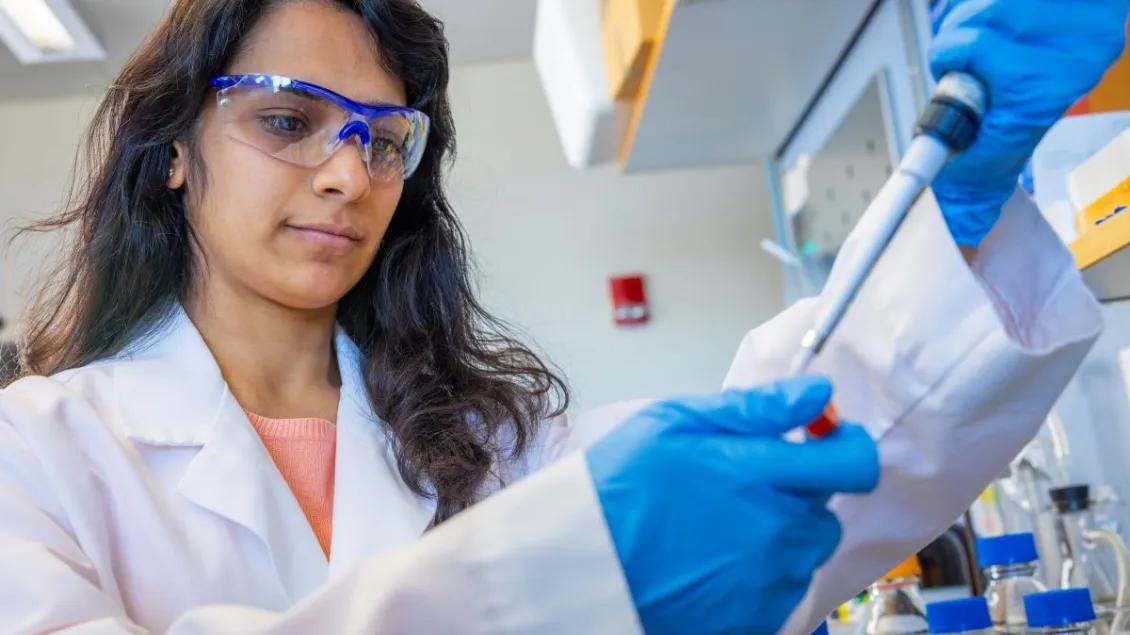 Woman scientist in the U-M Burant Lab holding a pipette 