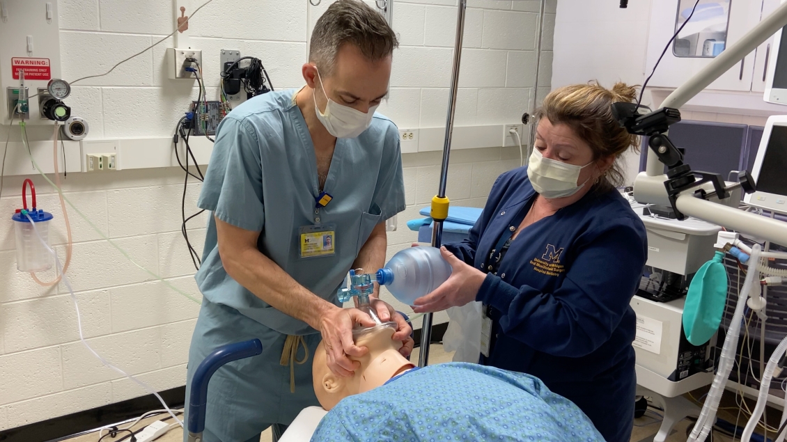 Team members demonstrating a medical technique with a dummy