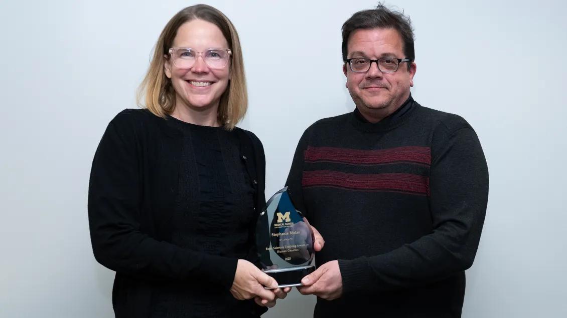 twp faculty professors standing together holding a glass award