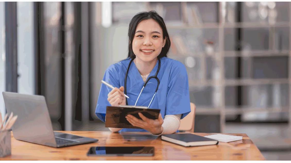 Medical student with stethoscope writing on clipboard