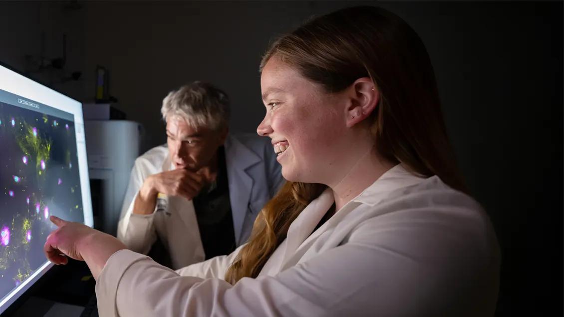 two researchers looking at a screen