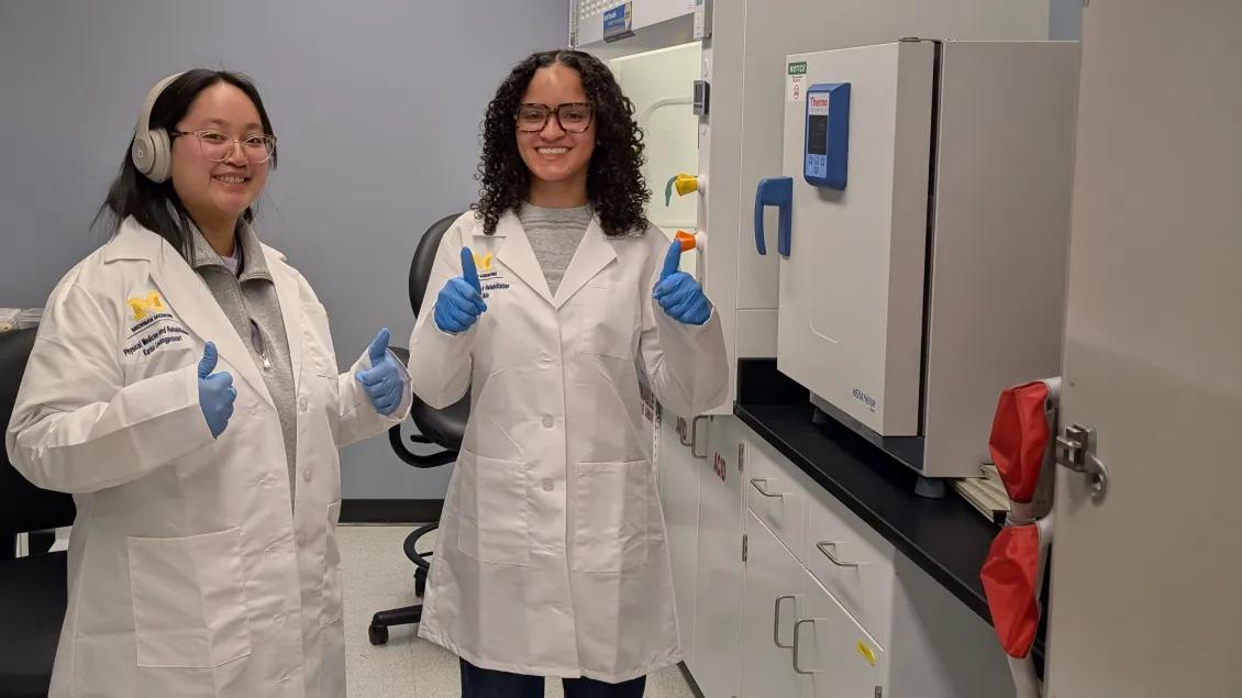 young researchers working in a lab and smiling at the camera