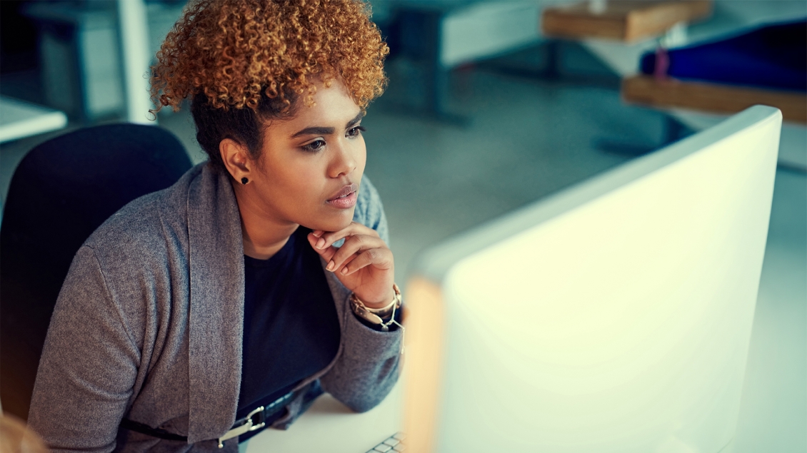 woman leaning in to look at a computer screen