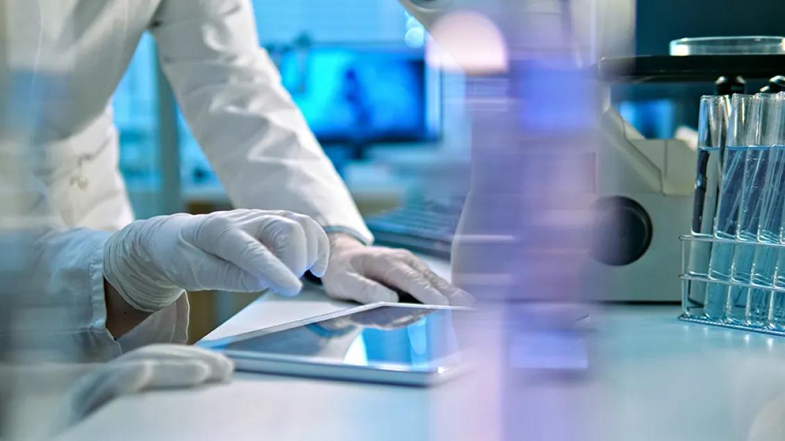 close-up of researcher using an ipad in a lab