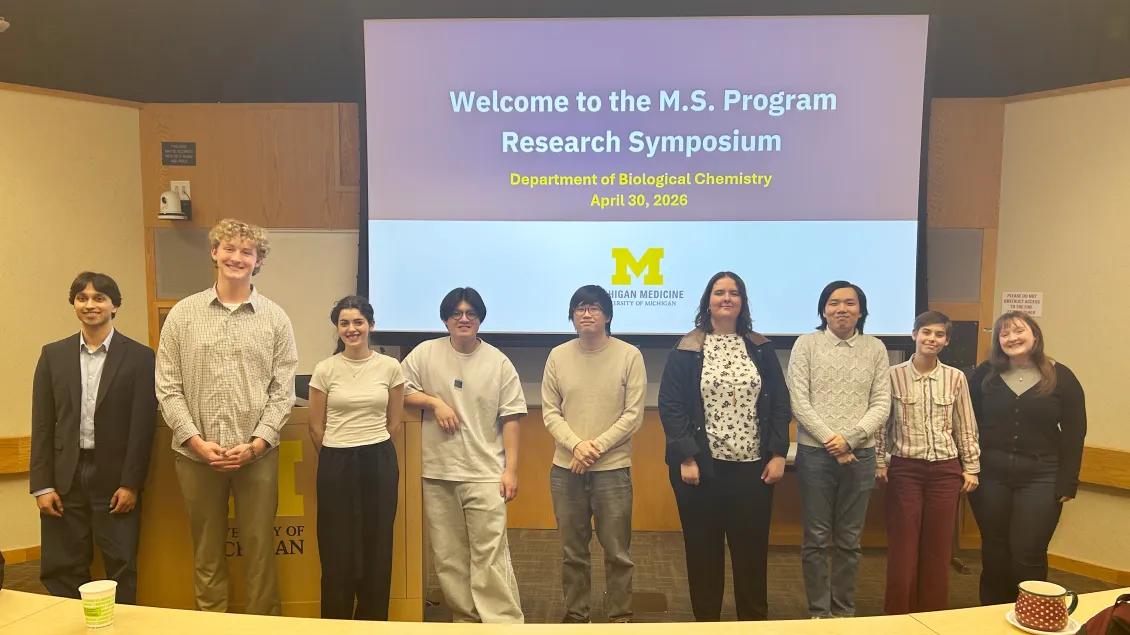 9 students at the front of an auditorium