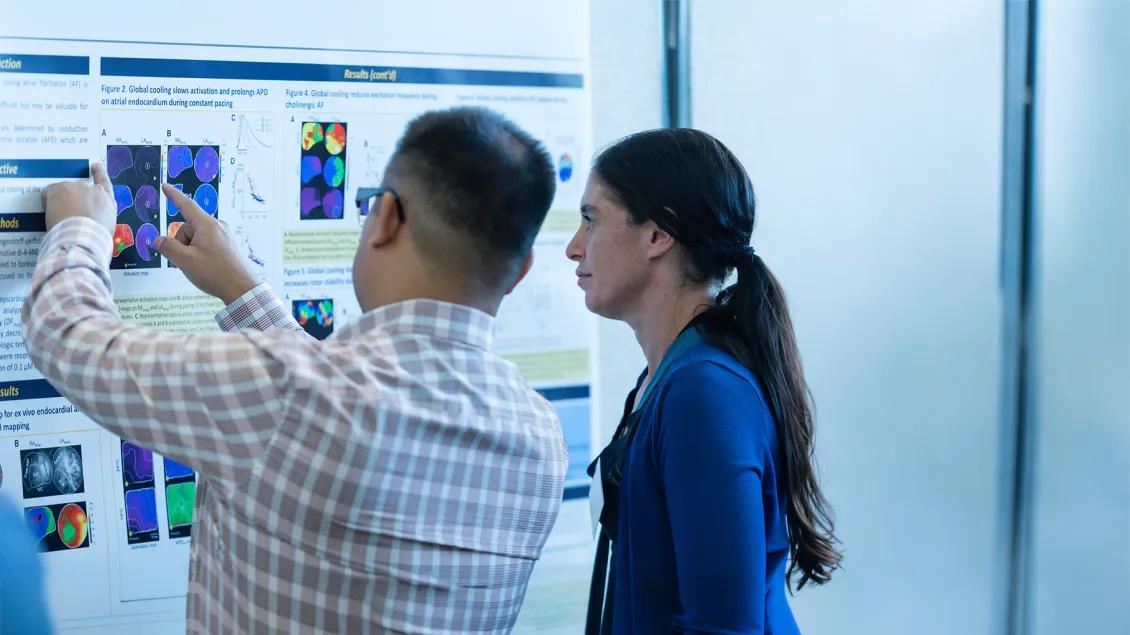 two people looking at a poster presentation display