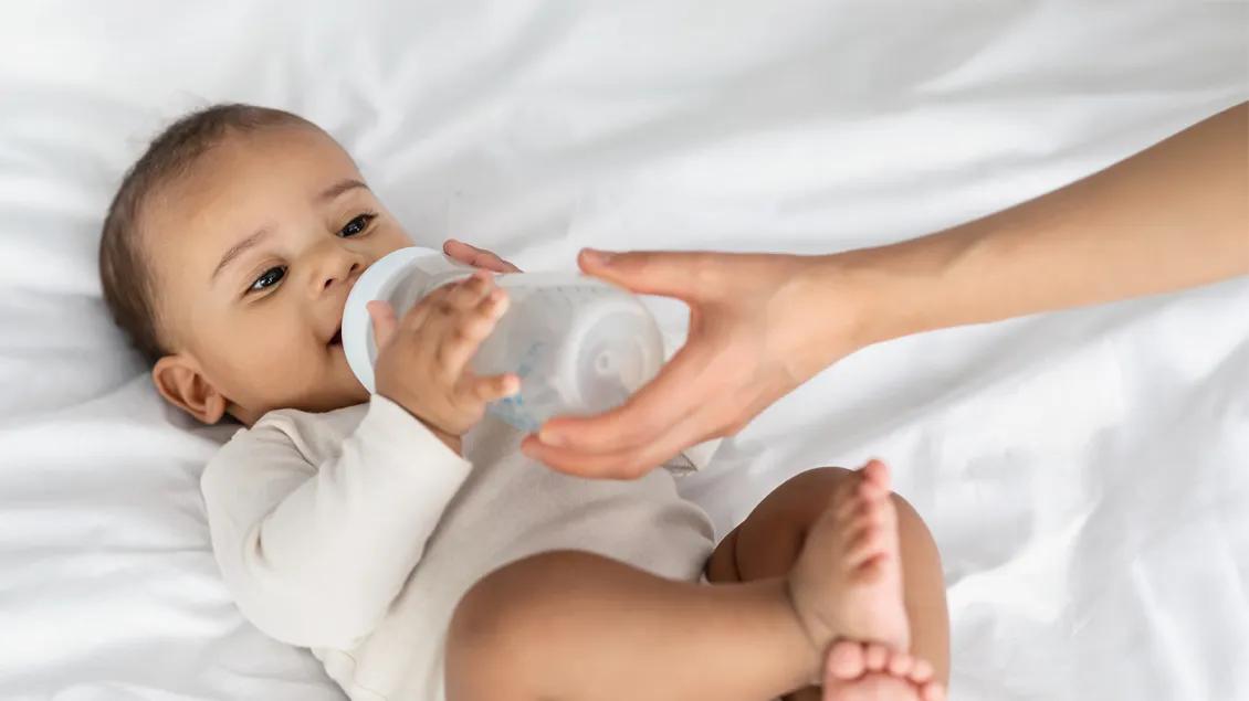 happy baby drinking from a bottle