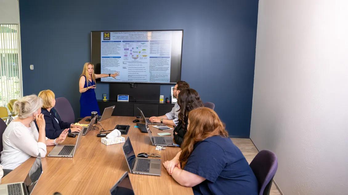 group in a conference room looking at a presentation screen