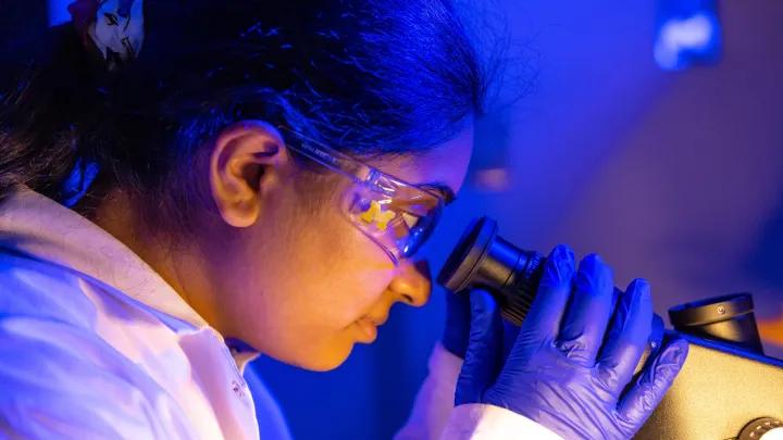 Zoomed in view of scientist looking through microscope 