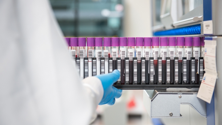 Photo of researcher extracting vials from a machine