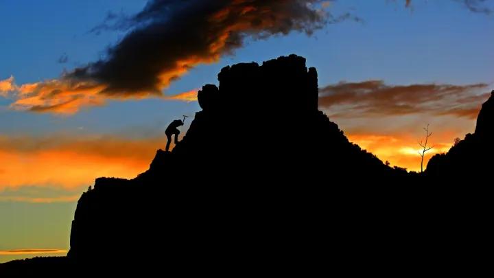 climber on a rocky outcrop at dusk