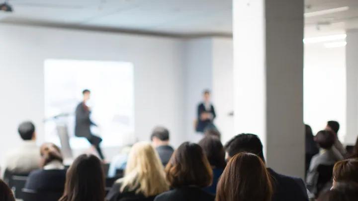 a crowd of people facing two presenters 