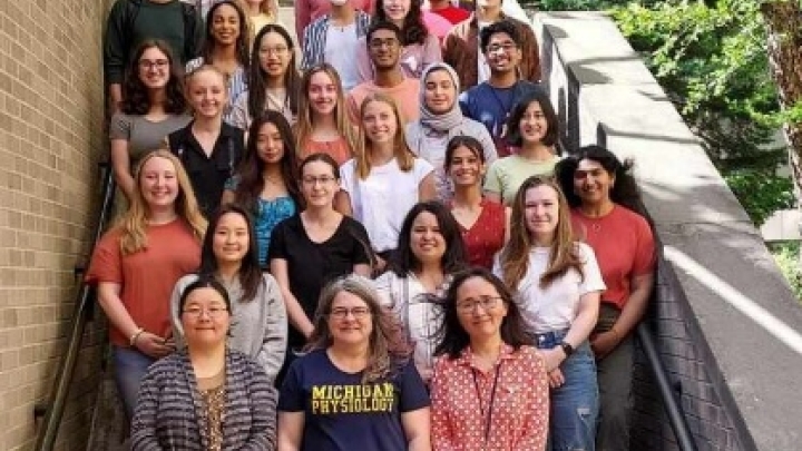 A group of student standing on stairs and posing for a photo.