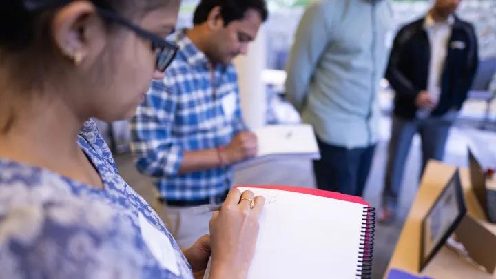A group of people take notes during an event.