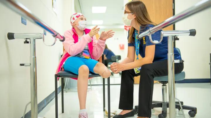 Health care provider talking to a pediatric cancer patient
