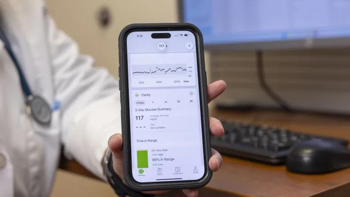 Doctor showing a phone monitoring diabetes