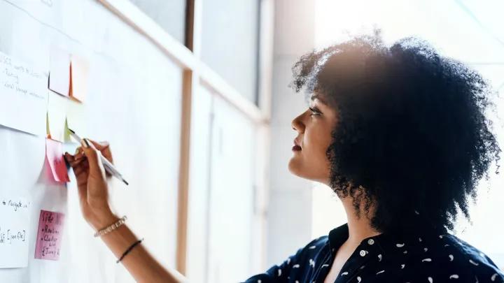 a woman brainstorming at a whiteboard