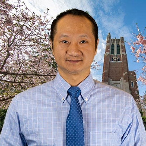 an Asian man with a blue shirt and tie 