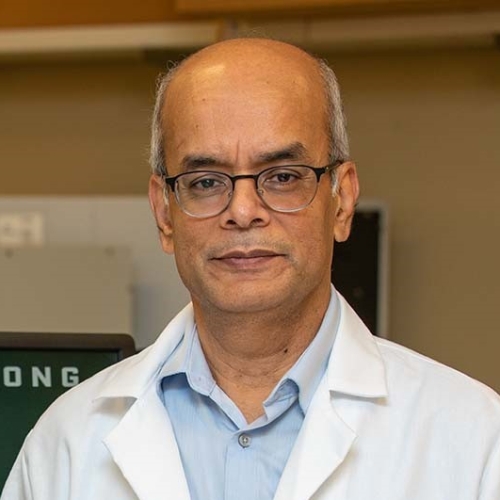 a bald man wearing a white coat 