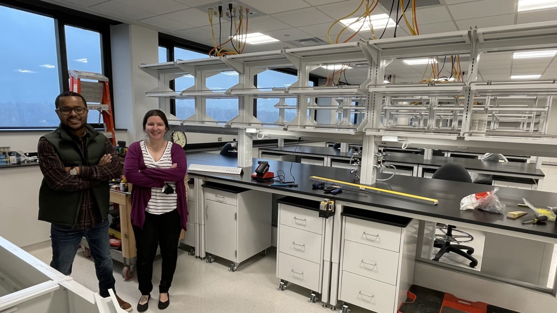 Two young faculty members stand in a newly renovated laboratory