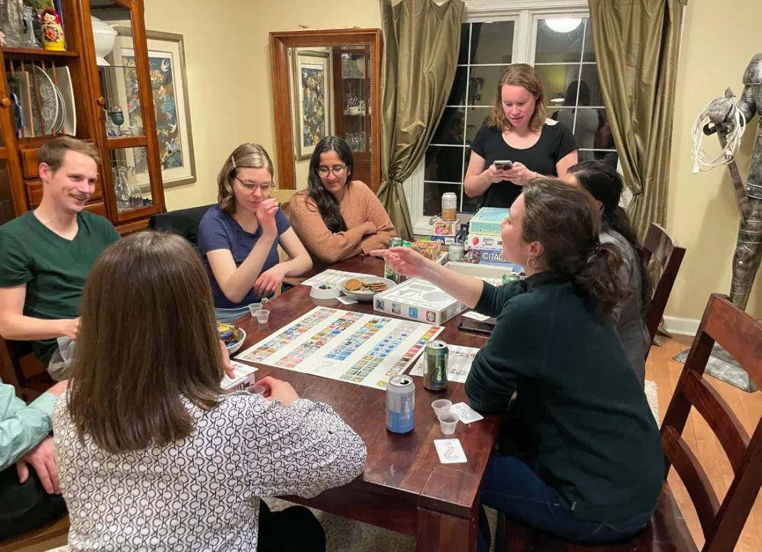 A group of people sitting around a table playing a game