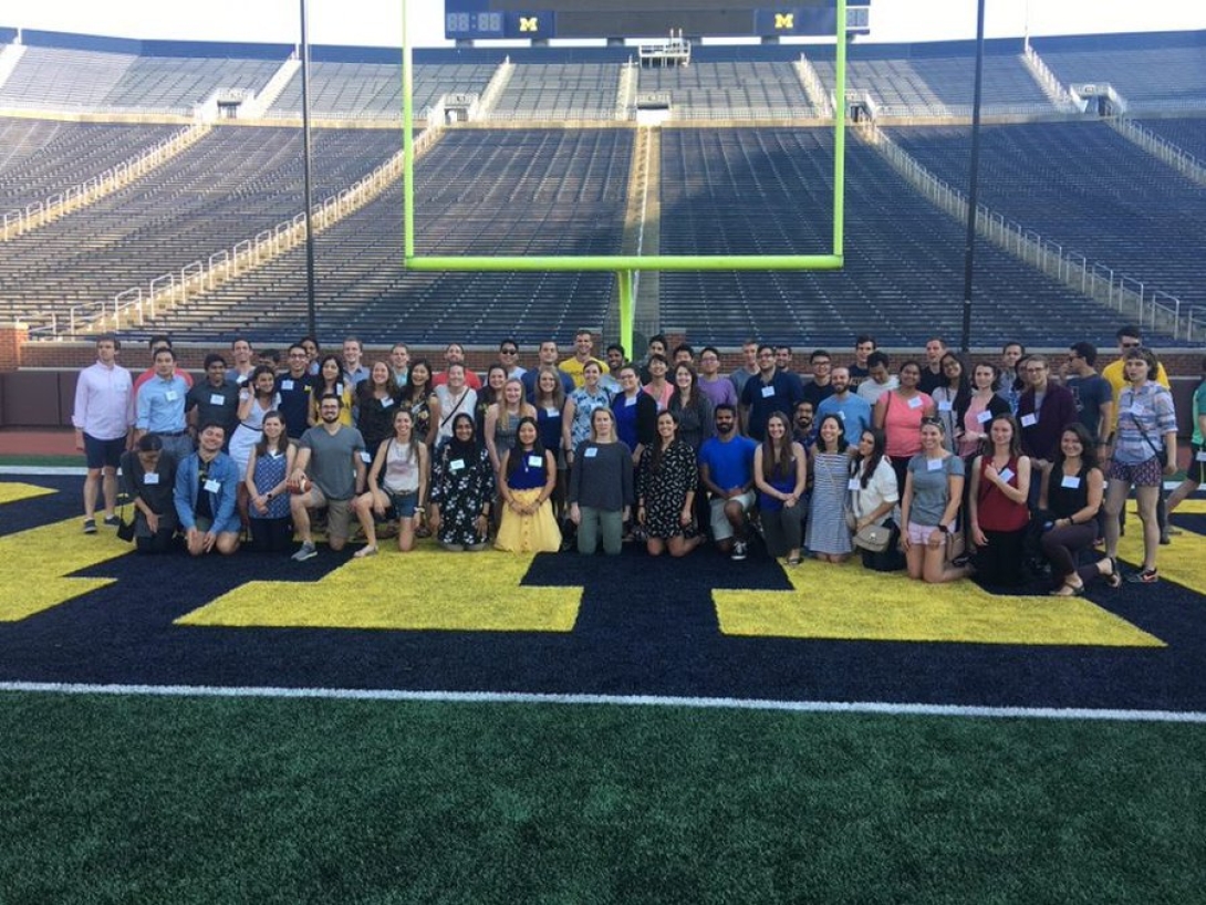 Dozens of residents pose for a photo on the football field