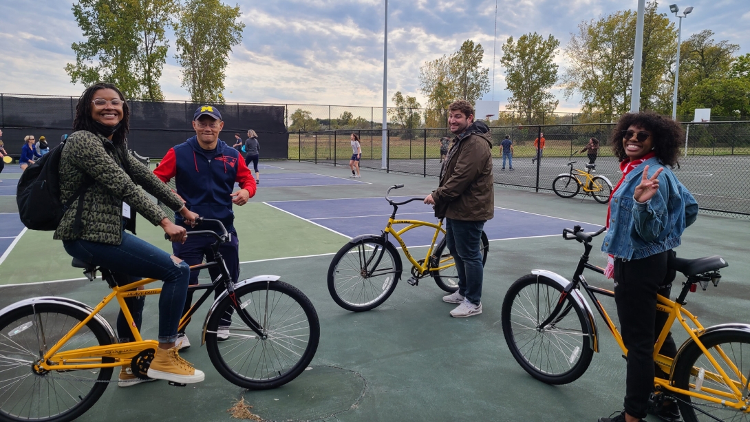 faculty and students on bikes during an outdoor gathering